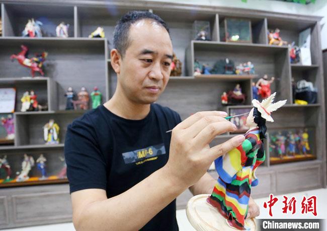 圖為安秋平正在創(chuàng)作代表隴南文縣民俗的《白馬人》作品?！「哒?攝