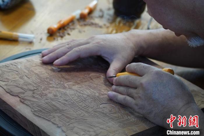 圖為徐晉林湊近木板，近距離制作雕版畫?！【琶赖┰?　攝