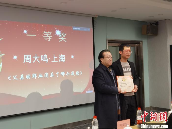 圖為作家、西北師范大學(xué)新聞與傳媒學(xué)院院長(zhǎng)徐兆壽頒發(fā)一等獎(jiǎng)證書，代領(lǐng)獎(jiǎng)?wù)呱吓_(tái)領(lǐng)獎(jiǎng)。　楊娜 攝