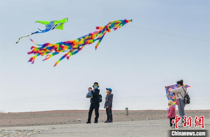 圖為孩童在父母的陪伴下放風(fēng)箏。　王斌銀 攝