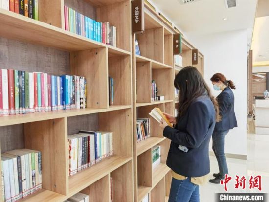 圖為在甘肅公航旅建設集團有限公司的職工書屋，職工挑選書籍。　徐雪 攝