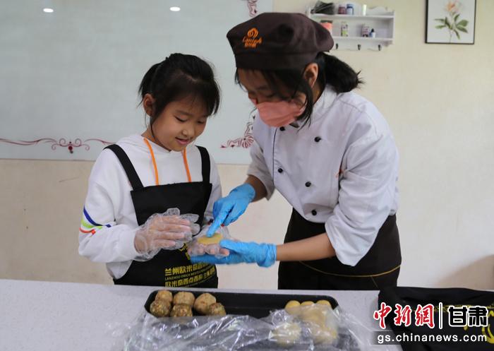 圖為在甘臺胞小朋友在工作人員指導(dǎo)下制作月餅。九美旦增 攝