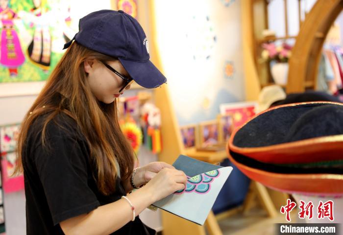 圖為民眾體驗(yàn)國(guó)家級(jí)非遺項(xiàng)目盤(pán)繡技藝。　薛蒂 攝