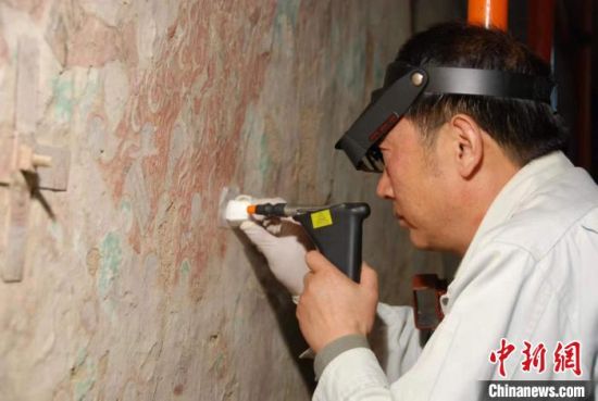 敦煌研究院研究員樊再軒進行壁畫修復(fù)。(資料圖)張云文 攝