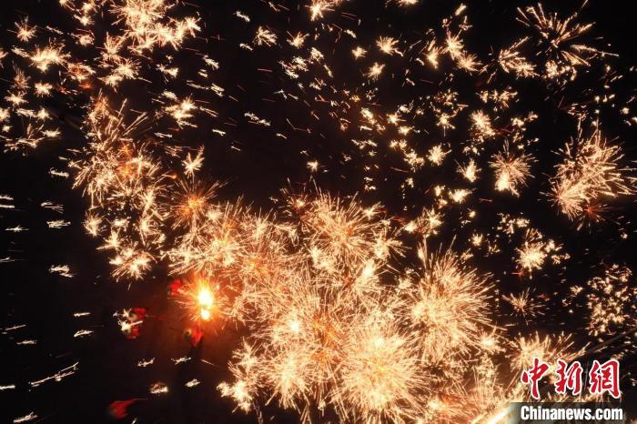 灼熱的鐵水在空中迸散。在空中形成“鐵花火雨”的景象，似天女散花，似群星漫天，如夢如幻，美不勝收。侯奇志 攝</p>
<p>