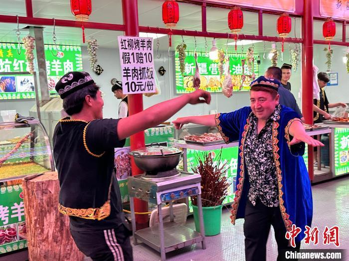 圖為餐飲經(jīng)營(yíng)者在“西涼不夜城”跳起舞蹈引客?！〈魑牟?攝</p><p>