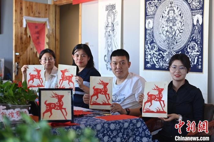 6月6日，在甘肅敦煌青年夜校課程中，青年學(xué)員展示學(xué)習(xí)敦煌非遺剪紙的成果。李亞龍 攝　　