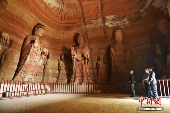 7月15日，游人參觀甘肅省平?jīng)鍪袥艽h百里石窟長(zhǎng)廊中的南石窟寺1號(hào)窟。百里石窟長(zhǎng)廊位于涇川縣境內(nèi)，由512個(gè)石窟、5眼窟中石井組成，現(xiàn)存王母宮石窟、鳳凰山石窟、南石窟寺、丈八寺石窟、羅漢洞石窟、太山寺石窟等規(guī)模較大的石窟群，還有數(shù)量眾多的小石窟群。南石窟寺開(kāi)鑿于北魏永平三年，其中1號(hào)窟屬于大型七佛窟，七佛高達(dá)6米。中新社記者 李亞龍 攝