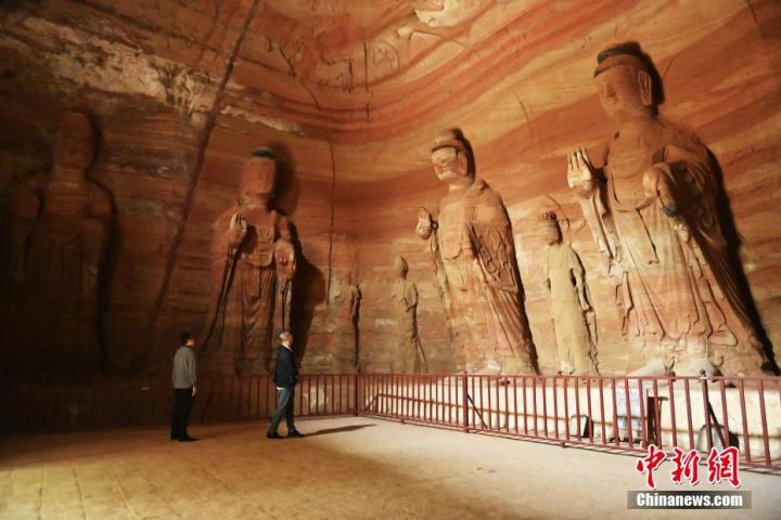 7月15日，游人參觀甘肅省平?jīng)鍪袥艽h百里石窟長(zhǎng)廊中的南石窟寺1號(hào)窟。百里石窟長(zhǎng)廊位于涇川縣境內(nèi)，由512個(gè)石窟、5眼窟中石井組成，現(xiàn)存王母宮石窟、鳳凰山石窟、南石窟寺、丈八寺石窟、羅漢洞石窟、太山寺石窟等規(guī)模較大的石窟群，還有數(shù)量眾多的小石窟群。南石窟寺開(kāi)鑿于北魏永平三年，其中1號(hào)窟屬于大型七佛窟，七佛高達(dá)6米。中新社記者 李亞龍 攝