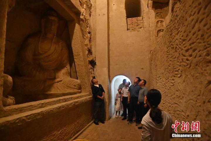 7月15日，游人參觀甘肅省平?jīng)鍪袥艽h百里石窟長(zhǎng)廊中的王母宮石窟。百里石窟長(zhǎng)廊位于涇川縣境內(nèi)，由512個(gè)石窟、5眼窟中石井組成，現(xiàn)存王母宮石窟、鳳凰山石窟、南石窟寺、丈八寺石窟、羅漢洞石窟、太山寺石窟等規(guī)模較大的石窟群，還有數(shù)量眾多的小石窟群。王母宮石窟又名千佛洞，該窟設(shè)計(jì)宏大，造像生動(dòng)，窟內(nèi)擁有造像數(shù)百尊，是較為珍貴的佛教文化歷史遺存。中新社記者 李亞龍 攝</p>
<p>