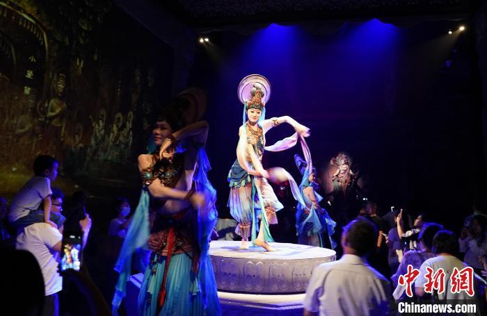 《樂動敦煌》是全球首部洞窟式沉浸體驗劇，利用真人與數(shù)字影像虛實交換實現(xiàn)沉浸式體驗。圖為2023年8月28日晚，《樂動敦煌》演出。(資料圖)中新社記者 毛建軍 攝